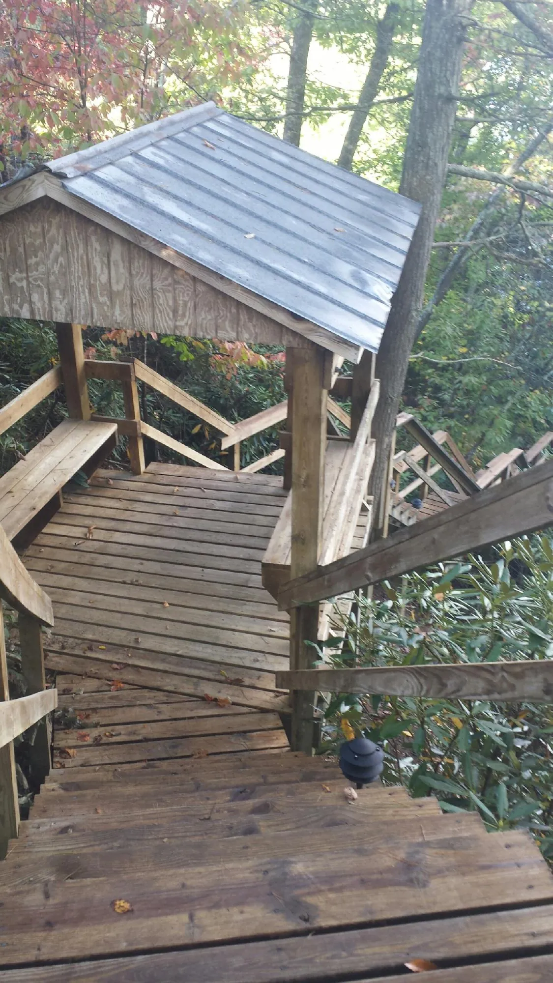 Metal roofed shelter over wooden steps on a wooded walkway — Skylight Repair & Installation work by our crew in Mechanic Falls